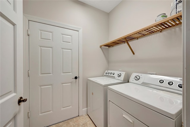 clothes washing area featuring washing machine and clothes dryer and light tile patterned floors