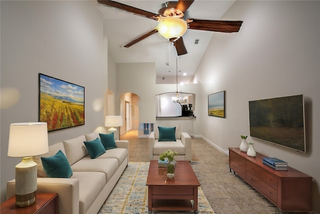 living room featuring high vaulted ceiling and ceiling fan with notable chandelier