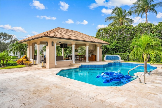 view of pool with exterior bar, a patio, and an outdoor kitchen