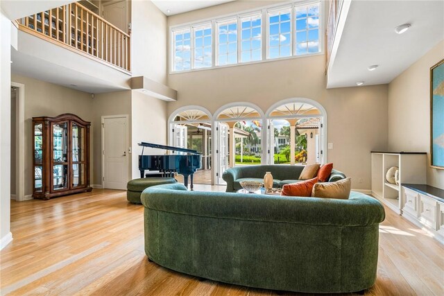 740 Lagoon Rd, Vero Beach, FL 32963 - living room with a high ceiling, light wood-style flooring, healthy amount of natural light, and baseboards