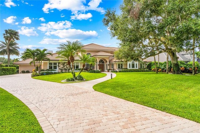 740 Lagoon Rd, Vero Beach, FL 32963 - mediterranean / spanish home featuring decorative driveway, a front yard, stucco siding, and an attached garage