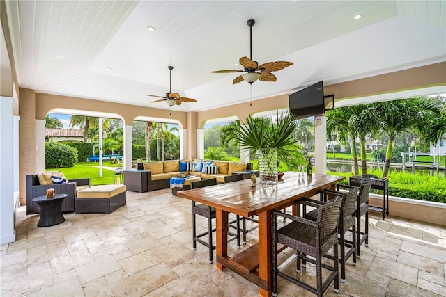 sunroom / solarium with ceiling fan and wood ceiling