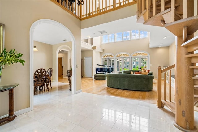 living room with light tile patterned floors and a towering ceiling