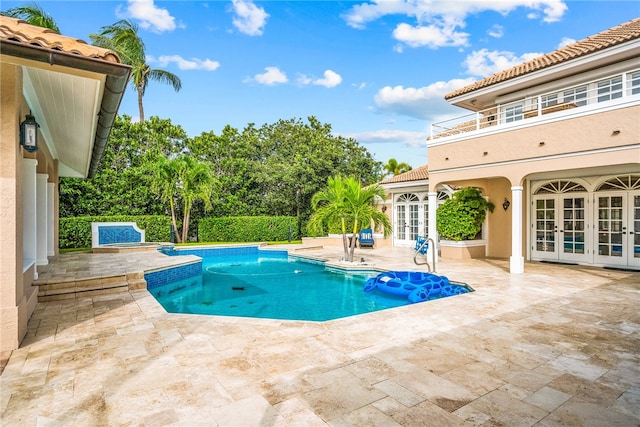 view of swimming pool with french doors and a patio