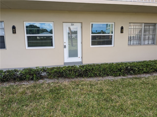 entrance to property featuring a yard