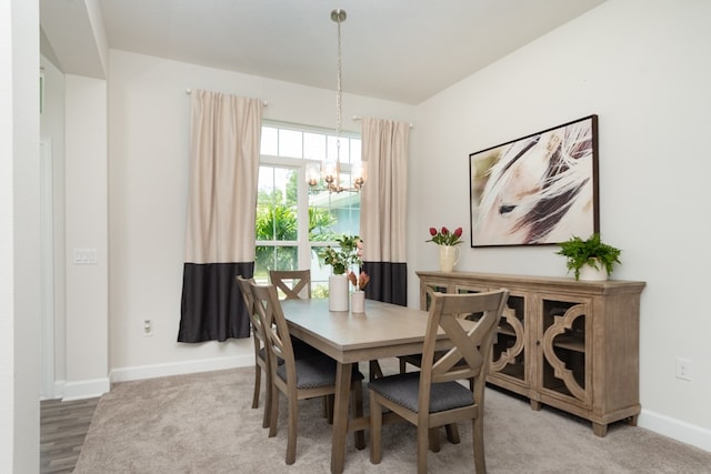 dining area with wood-type flooring and a notable chandelier