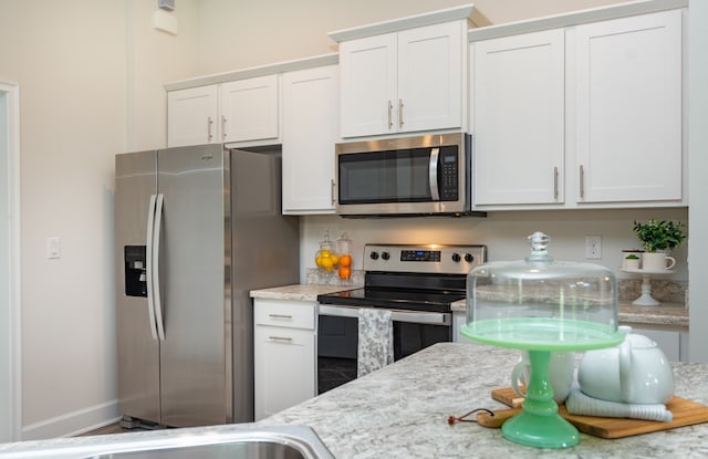 kitchen with white cabinets and appliances with stainless steel finishes