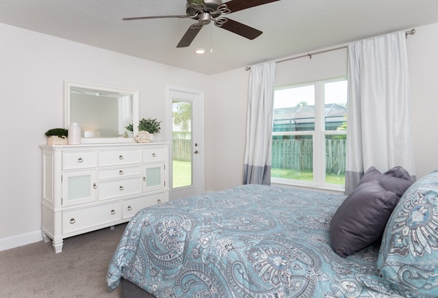 carpeted bedroom featuring access to outside, multiple windows, and ceiling fan