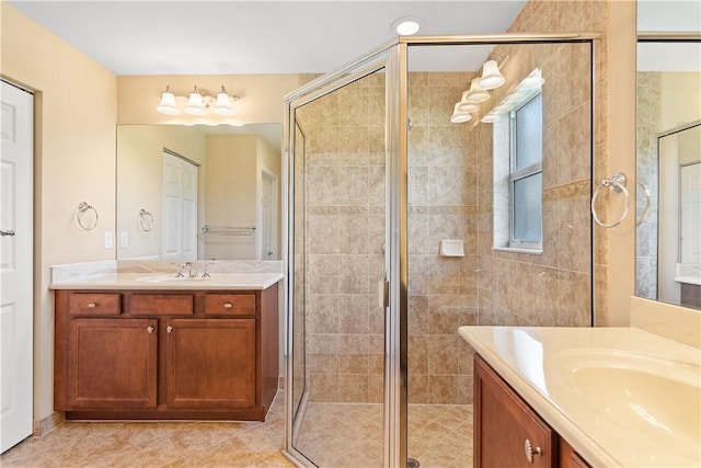 full bath with a sink, a stall shower, tile patterned flooring, and two vanities