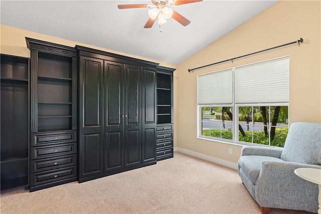 living area with lofted ceiling, light colored carpet, ceiling fan, and baseboards