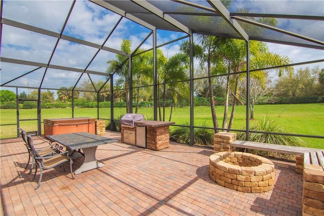 view of patio with an outdoor fire pit, a lanai, a grill, and a hot tub