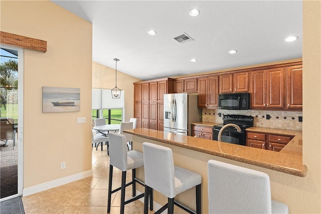 kitchen featuring black appliances, a wealth of natural light, backsplash, and visible vents