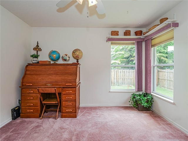 unfurnished office with ceiling fan and light carpet