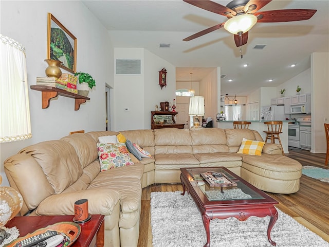 living room featuring lofted ceiling, hardwood / wood-style floors, and ceiling fan