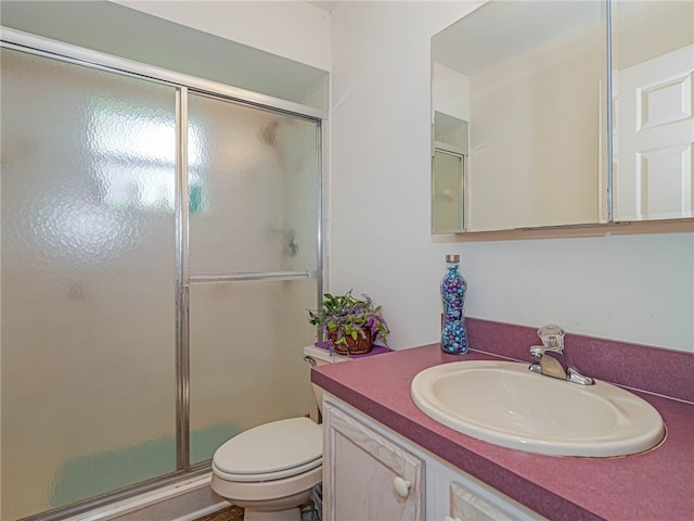 bathroom with vanity, toilet, and an enclosed shower