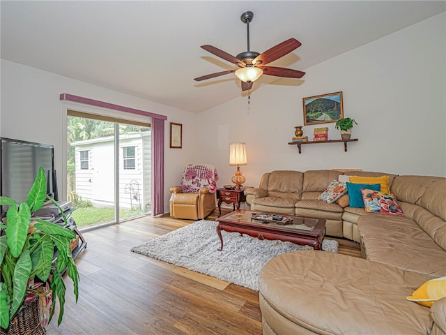 living room with light hardwood / wood-style floors, ceiling fan, and vaulted ceiling