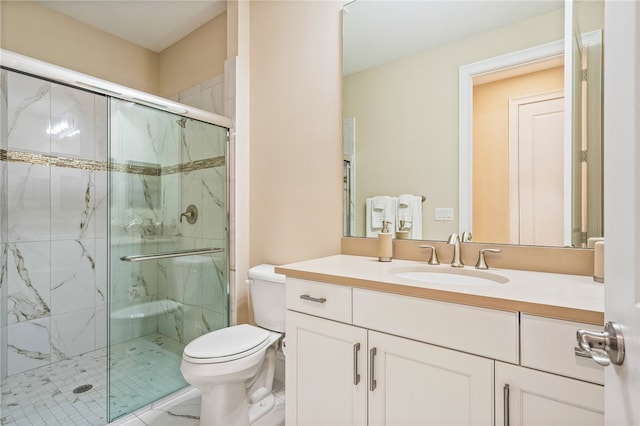 bathroom with vanity, a shower with shower door, and toilet