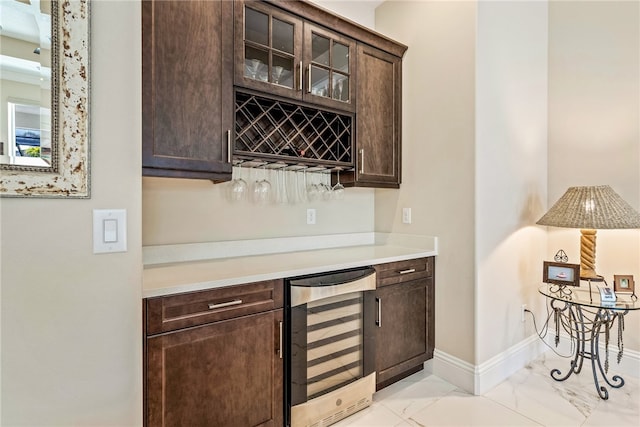 bar with dark brown cabinets and wine cooler