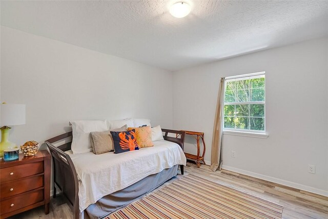 435 61st Ave, Vero Beach, FL 32968 - bedroom with light wood-type flooring, a textured ceiling, and baseboards