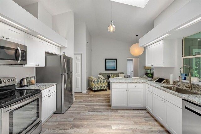 435 61st Ave, Vero Beach, FL 32968 - kitchen with appliances with stainless steel finishes, a sink, a peninsula, white cabinetry, and light wood finished floors