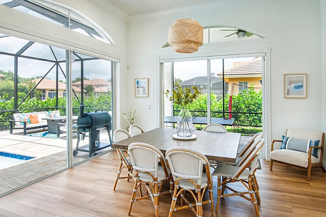 dining room featuring light wood-type flooring, ceiling fan, and crown molding