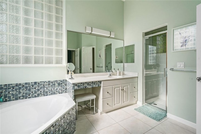 919 Island Club Sq, Vero Beach, FL 32963 - bathroom featuring tile patterned flooring, vanity, baseboards, a garden tub, and a stall shower