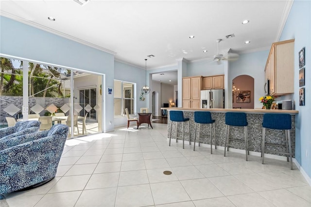 919 Island Club Sq, Vero Beach, FL 32963 - interior space with crown molding, appliances with stainless steel finishes, a breakfast bar area, light tile patterned floors, and visible vents