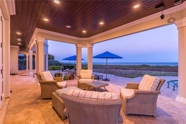 patio terrace at dusk featuring a water view and an outdoor hangout area