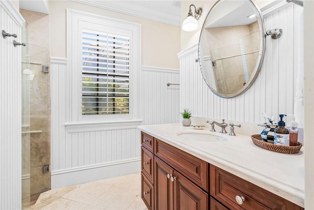 bathroom with a shower with door, vanity, ornamental molding, and tile patterned flooring