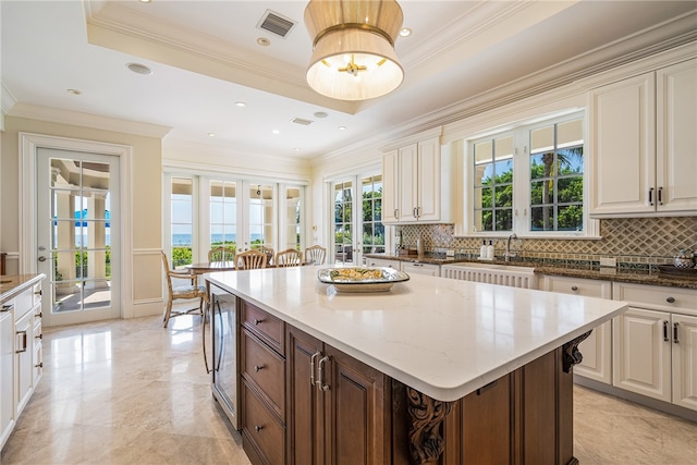 kitchen featuring tasteful backsplash, a center island, and light stone counters