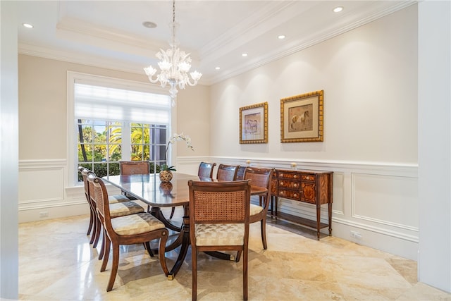 dining area with ornamental molding, a tray ceiling, and a notable chandelier