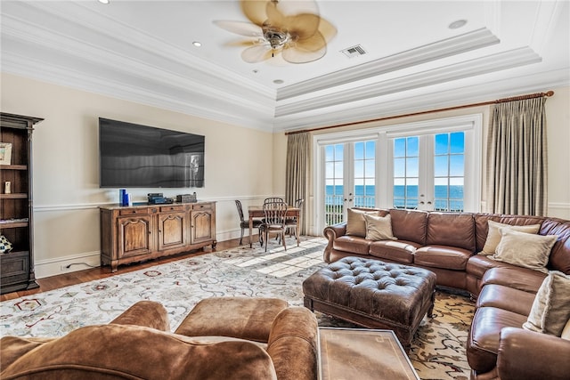 living room featuring hardwood / wood-style flooring, ceiling fan, ornamental molding, and french doors