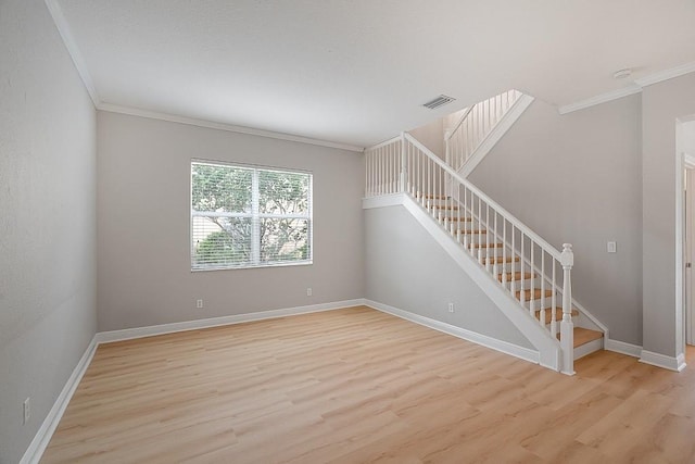 empty room with light hardwood / wood-style flooring and ornamental molding