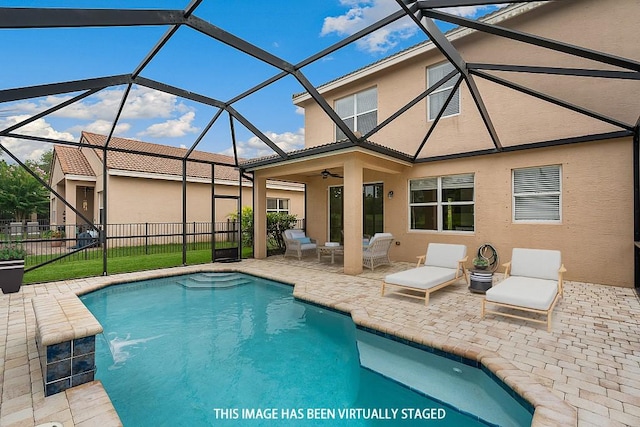 view of pool featuring pool water feature, glass enclosure, a patio, and ceiling fan