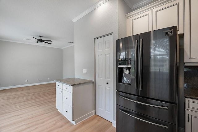 kitchen with baseboards, black fridge with ice dispenser, ornamental molding, ceiling fan, and light wood finished floors