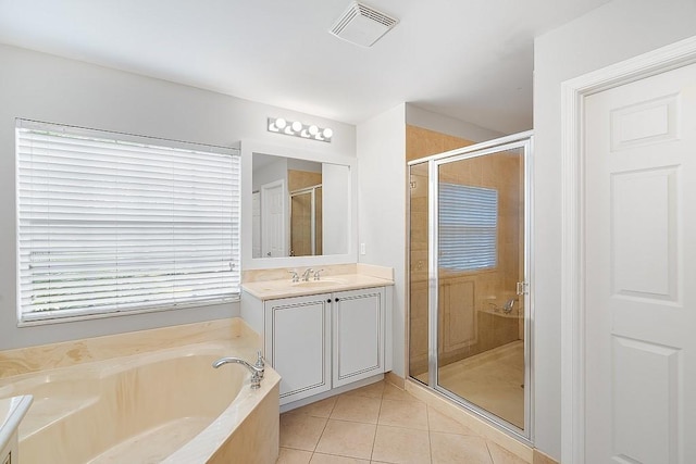 bathroom with vanity, tile patterned flooring, and plus walk in shower