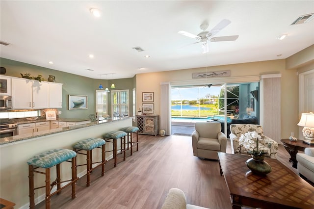 living room featuring light wood-type flooring and ceiling fan