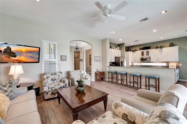 living room with ceiling fan, sink, and light hardwood / wood-style flooring