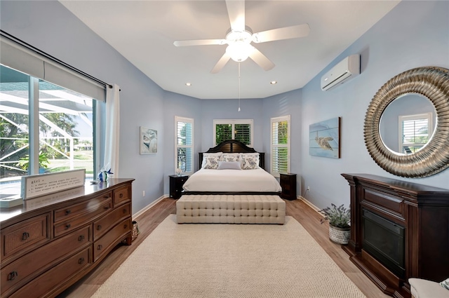 bedroom featuring ceiling fan, multiple windows, and a wall mounted air conditioner