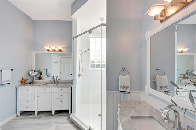 bathroom featuring a shower with door and vanity