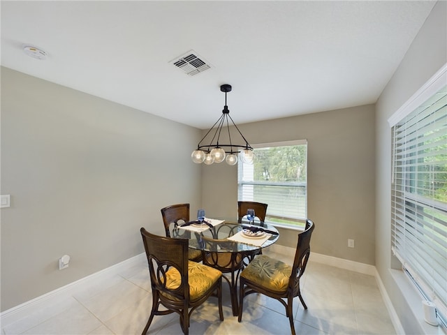 dining area featuring light tile patterned floors and a notable chandelier