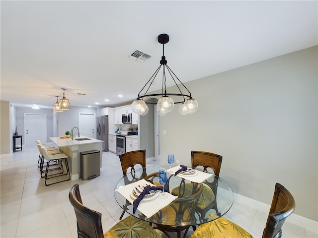 dining area featuring sink and light tile patterned flooring