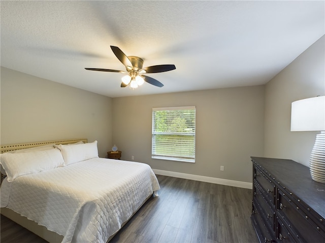 bedroom with dark hardwood / wood-style flooring, a textured ceiling, and ceiling fan