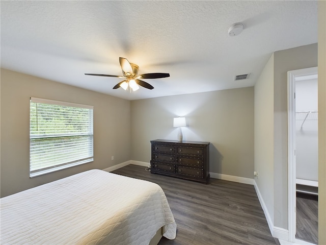 bedroom featuring a textured ceiling, ceiling fan, and dark hardwood / wood-style floors