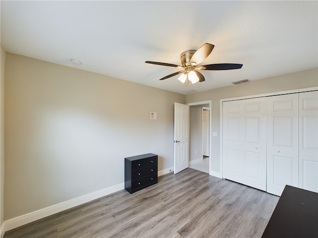 unfurnished bedroom with ceiling fan, a closet, and light hardwood / wood-style flooring