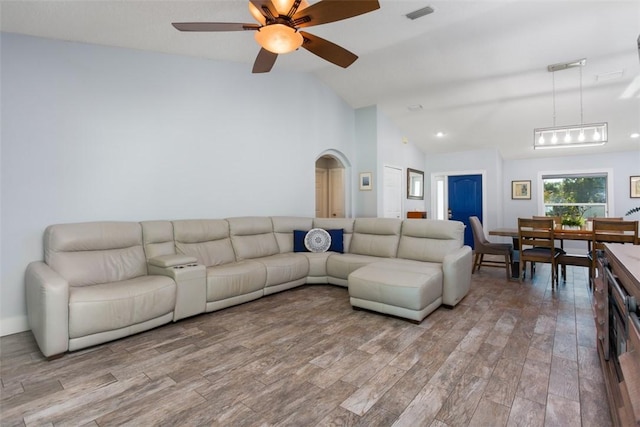 living room with light hardwood / wood-style flooring, ceiling fan, and vaulted ceiling