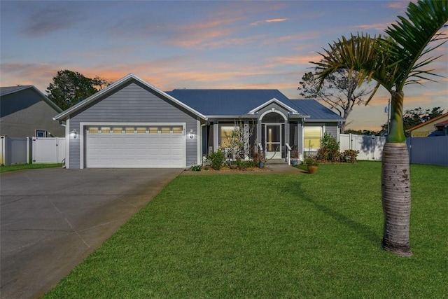 ranch-style home featuring a garage and a yard