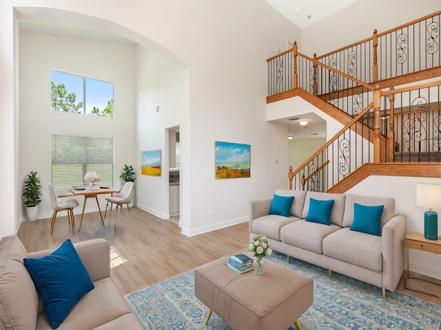 living room with high vaulted ceiling and wood-type flooring