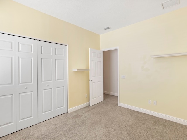 unfurnished bedroom with a closet and light carpet