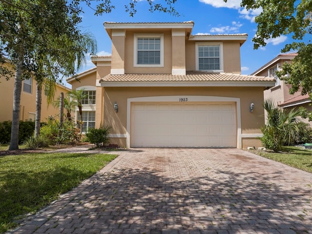 mediterranean / spanish house featuring a garage and a front yard